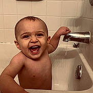 Oliver is registered to the contest to win money with this photo: baby, bathtub, bathroom, child, faucet, smiling, water, tiles, happy, tub, skin, hand, face, mouth, teeth, head, arm, indoor, person, cleaning