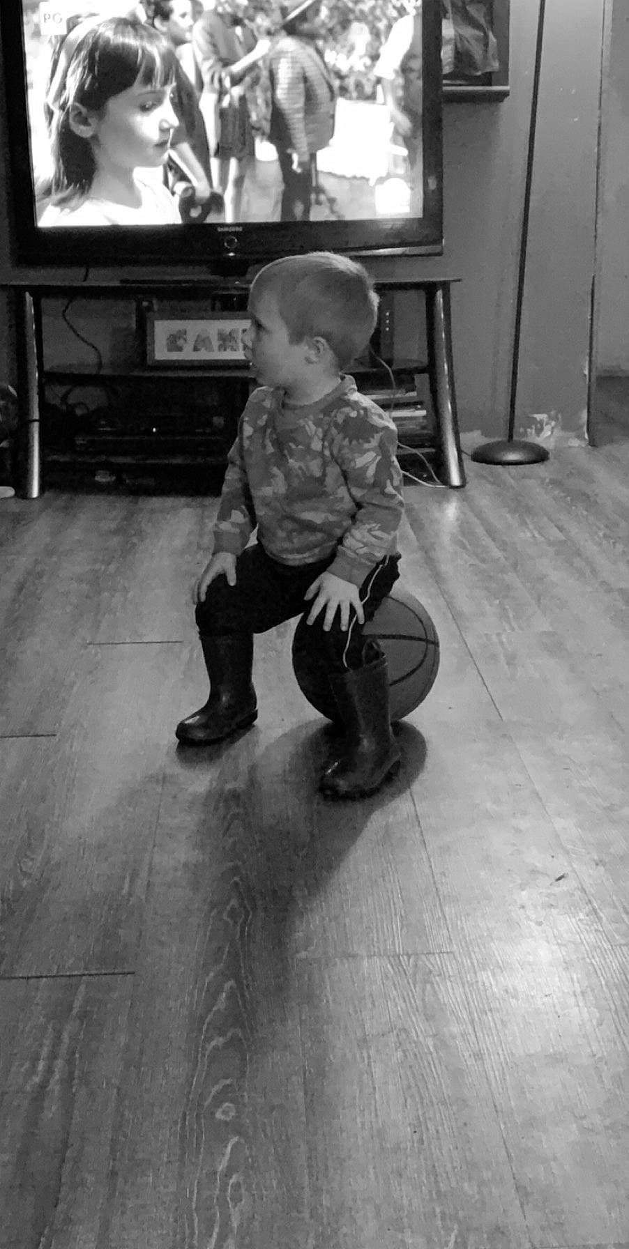 Deacon is registered to the contest to win money with this photo: black, black_and_white, child, floor, flooring, leg, monochrome, person, photograph, photography, play, shoe, sitting, snapshot, standing, style, toddler, white, wood
