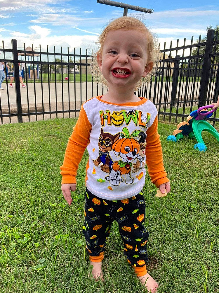 Kyren is registered to the contest to win money with this photo: baby, baby_toddler_clothing, child, cloud, facial_expression, fence, fun, grass, happy, head, joy, leisure, pajamas, pattern, people_in_nature, person, plant, sky, sleeve, smile