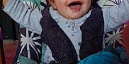 Saïd a rejoint le concours — aidez-le/la à gagner de superbes lots ! baby, child, smiling, pajamas, blanket, highchair, indoor, happy, face, person, furniture, television, colorful, pattern, seat, feet, cushion, home, cozy, infant