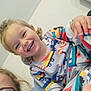 Saïd participe au concours pour gagner de l'argent avec cette photo : toddler, child, smiling, pajamas, curly_hair, glasses, adult, indoor, person, happy, face, clothing, sitting, closeup, joy, family, casual, light, background, portrait