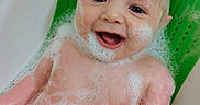 Atreyu is registered to the contest to win money with this photo: baby, bath, bubbles, foam, smile, child, skin, water, soap, head, face, arm, green, bathtub, happy, cute, infant, sitting, clean, playful