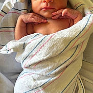 Sophia is registered to the contest to win money with this photo: newborn, baby, infant, sleeping, wrapped, blanket, striped_blanket, soft_texture, peaceful, cute, human, portrait, closeup, delicate, tiny_hands, resting, indoors, skin, head, face