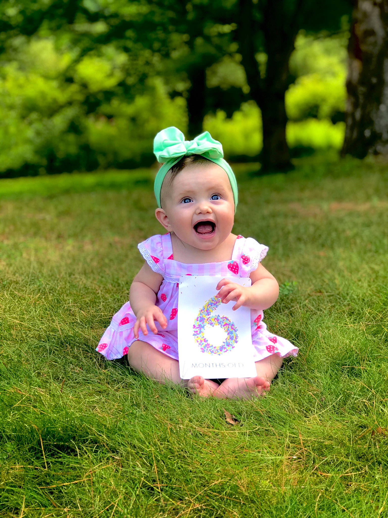 Quinn is registered to the contest to win money with this photo: baby, baby_toddler_clothing, eye, face, grass, grass_family, happy, hat, head, leaf, leisure, meadow, people_in_nature, person, pink, plant, playing_with_kids, smile, sun_hat, toddler