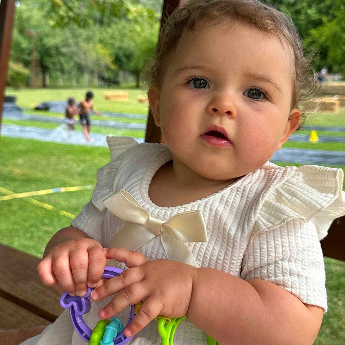 Callye participe au concours pour gagner de l'argent avec cette photo : baby, bow, child, curious, cute, face, grass, greenery, hands, infant, outdoor, park, people, play, portrait, slip_and_slide, summer, sunlight, toy, white_dress