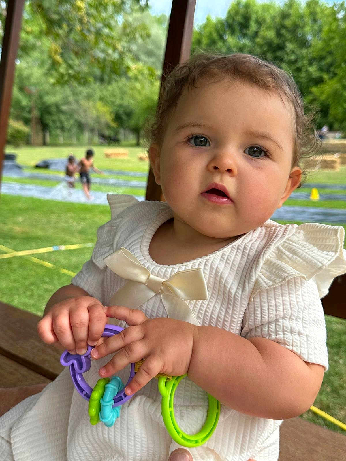 Callye participe au concours pour gagner de l'argent avec cette photo : baby, bow, child, curious, cute, face, grass, greenery, hands, infant, outdoor, park, people, play, portrait, slip_and_slide, summer, sunlight, toy, white_dress