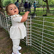 Callye a rejoint le concours — aidez-le/la à gagner de superbes lots ! casual, child, curious, daylight, fence, grass, greenery, group, metal_fence, nature, outdoor, park, people, person, shoes, standing, toddler, tree, white_clothing, young_child