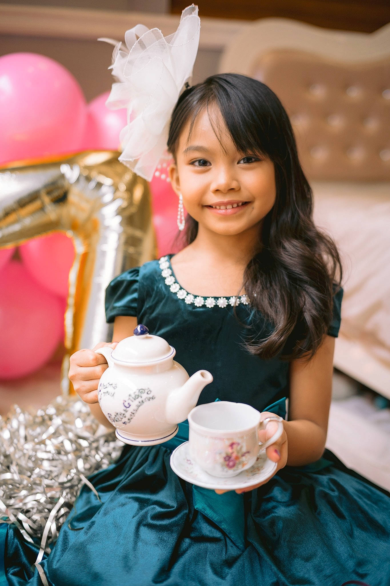 Ziah is registered to the contest to win money with this photo: balloon, beauty, birthday, child, dress, drinkware, event, fun, happy, holiday, icing, joy, party, party_supply, person, pink, sitting, smile, sweetness, tableware