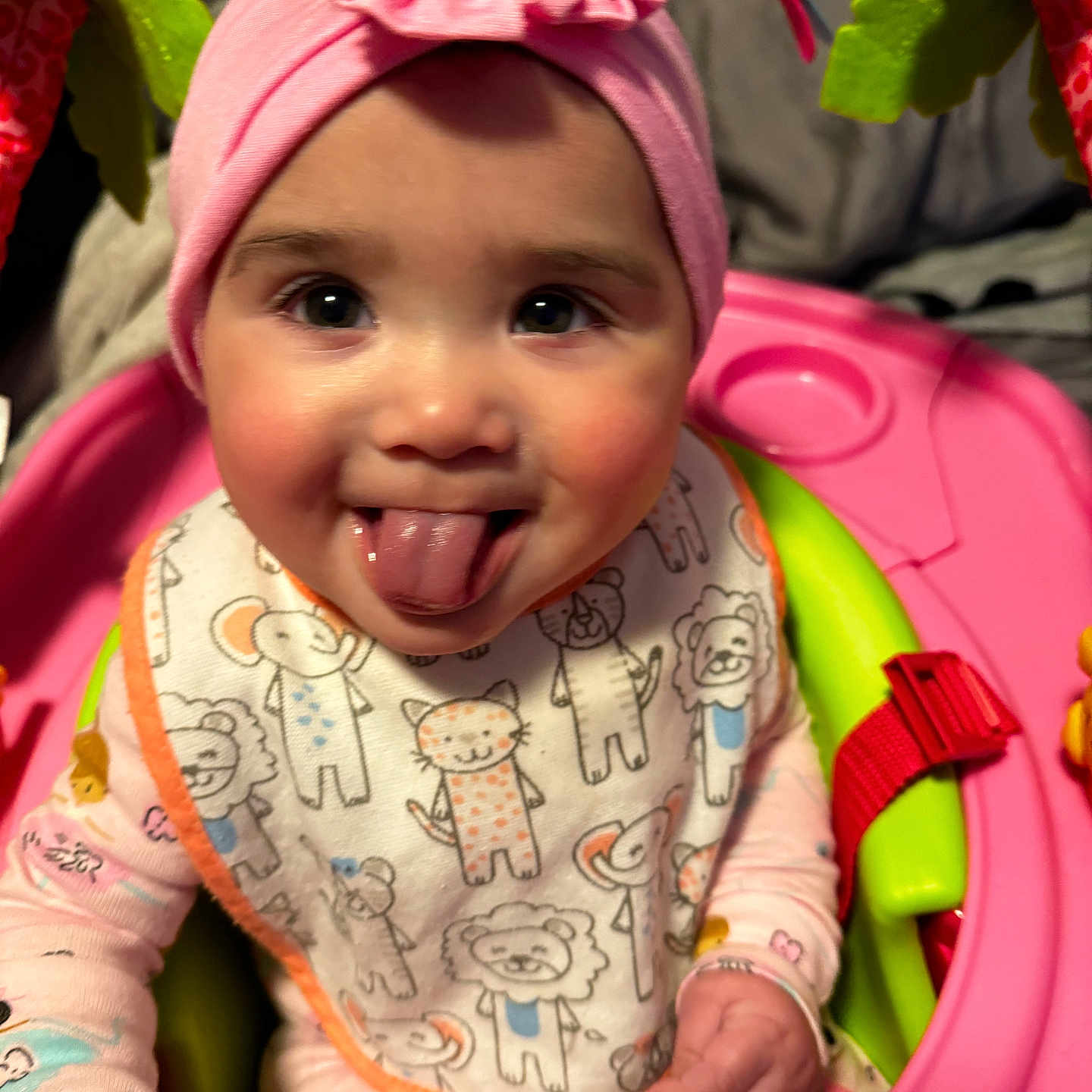 Camaria joined the competition — help win amazing prizes! animal_print, baby, baby_seat, bib, child, close_up, cute, face, green, happy, indoors, infant, pajamas, person, pink, pink_headband, playful, smiling, soft_toys, tongue_out