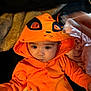 Camaria joined the competition — help win amazing prizes! baby, hoodie, orange_clothing, child, face, infant, blanket, hand, cute, expression, indoor, clothing, person, young_child, portrait, soft_texture, warm, cozy, sitting, looking