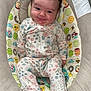 baby, infant, onesie, smiling, cute, plush_seat, disney, cartoon, bear_ears, child, patterned_clothing, happy, indoor, soft_texture, comfortable, seated, portrait, young_child, colorful, baby_seat