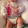 baby, child, infant, onesie, socks, cushion, blanket, face, legs, patterned, colorful, soft, cute, indoors, portrait, clothing, resting, babywear, playful, expression