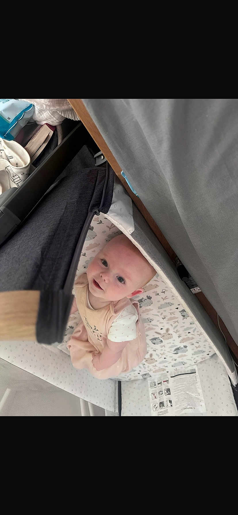 Autumn Bolding joined the competition — help win amazing prizes! baby, infant, playpen, patterned_bedding, soft_fabric, curious, looking_up, indoors, child, cute, person, newborn, pink_clothing, white_shirt, crib, floor, home, smiling, face, young_child