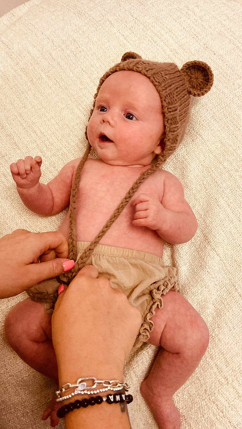 Autumn Bolding joined the competition — help win amazing prizes! baby, infant, knitted_hat, bear_ears, hands, nail_polish, blanket, texture, clothing, cute, lying_down, skin, expression, person, newborn, cozy, soft, adorable, child, warm
