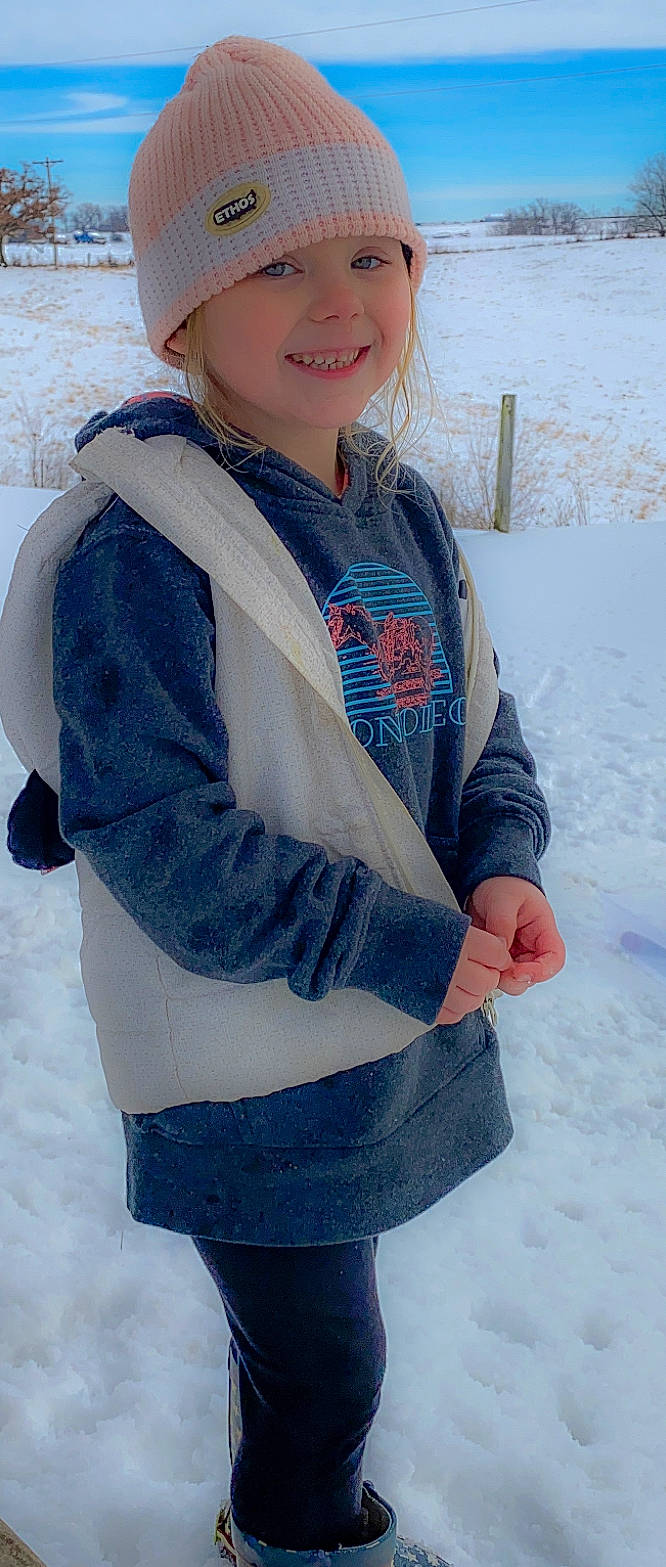 Caleigh is registered to the contest to win money with this photo: blue, bonnet, child_model, clothing, denim, electric_blue, freezing, glove, headwear, hood, ice, jacket, joy, parka, person, playing_in_the_snow, sleeve, snow, standing, street_fashion