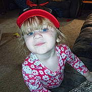 Eva is registered to the contest to win money with this photo: child, girl, blue_eyes, minnie_mouse_hat, hello_kitty, pajamas, smile, living_room, carpet, couch, notebook, toy, furniture, indoor, cute, playful, blonde_hair, person, young_child, cozy
