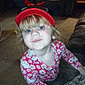 child, girl, blue_eyes, minnie_mouse_hat, hello_kitty, pajamas, smile, living_room, carpet, couch, notebook, toy, furniture, indoor, cute, playful, blonde_hair, person, young_child, cozy
