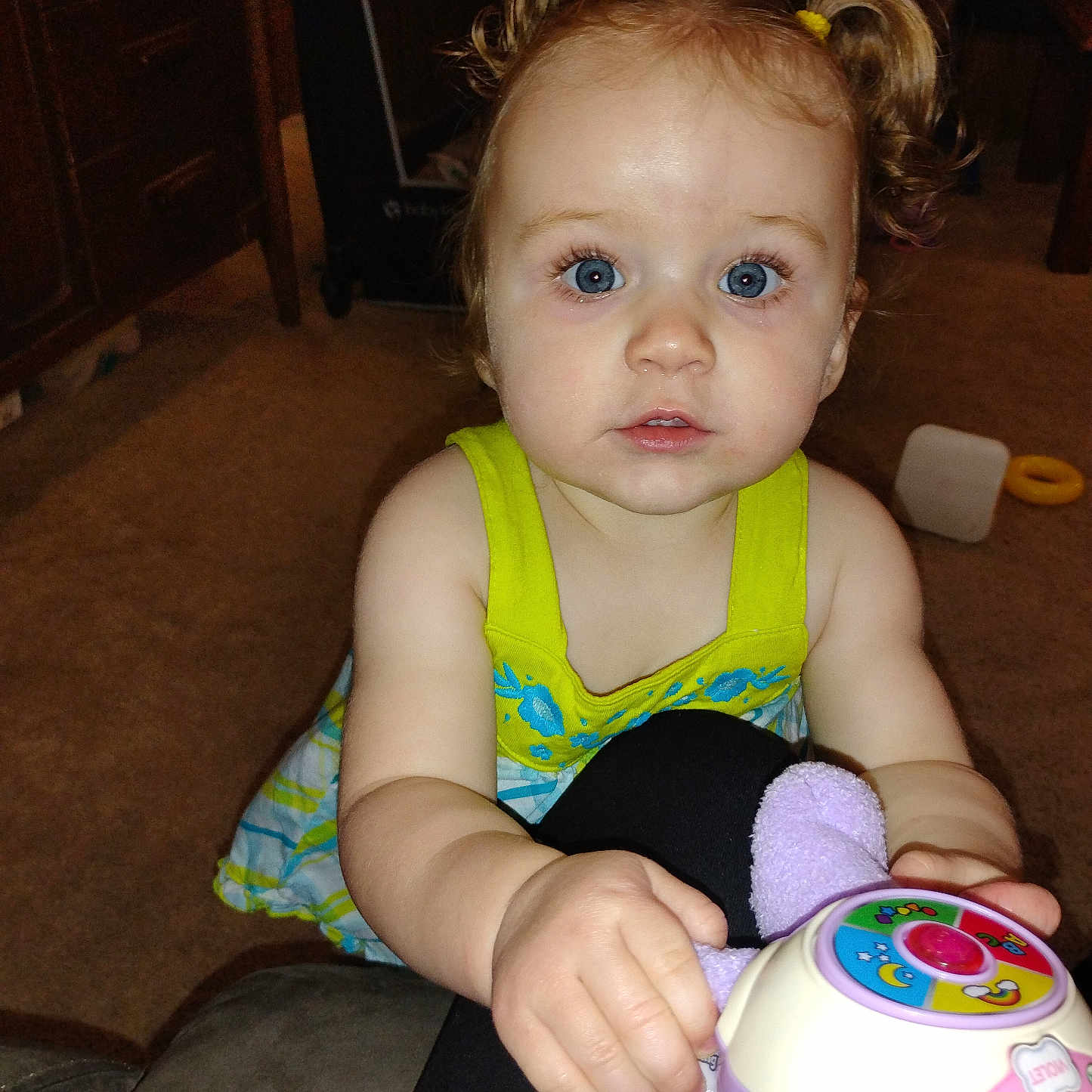 Eva joined the competition — help win amazing prizes! child, toddler, toy, indoor, blue_eyes, pigtails, curly_hair, carpet, furniture, dress, person, cute, baby, hand, expression, play, colorful, innocent, closeup, portrait