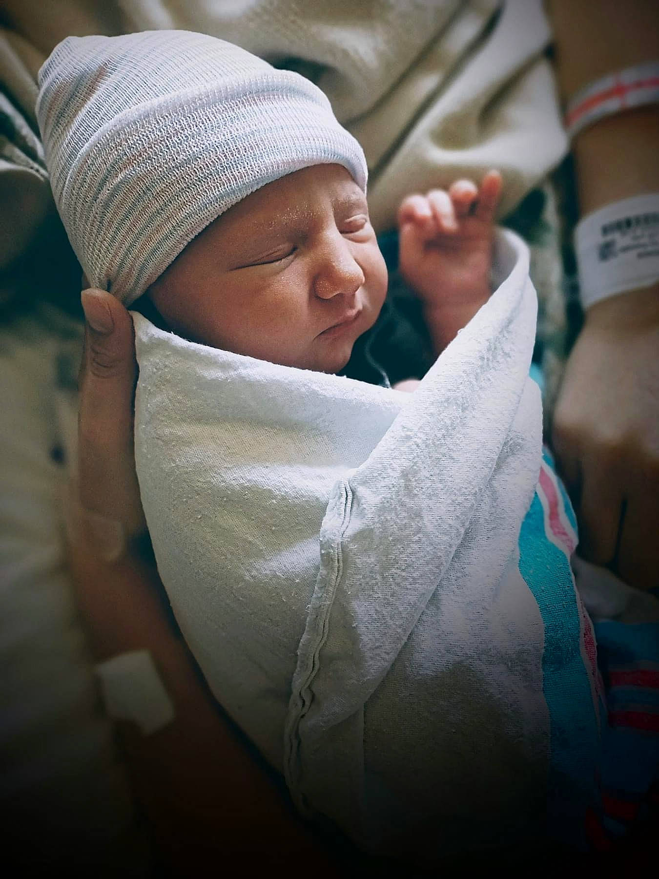 Jayke is registered to the contest to win money with this photo: baby, baby_sleeping, cap, child, comfort, elbow, flesh, gesture, hat, headwear, human_leg, linens, person, room, sitting, sleeve, thumb, toddler, wool, wrist