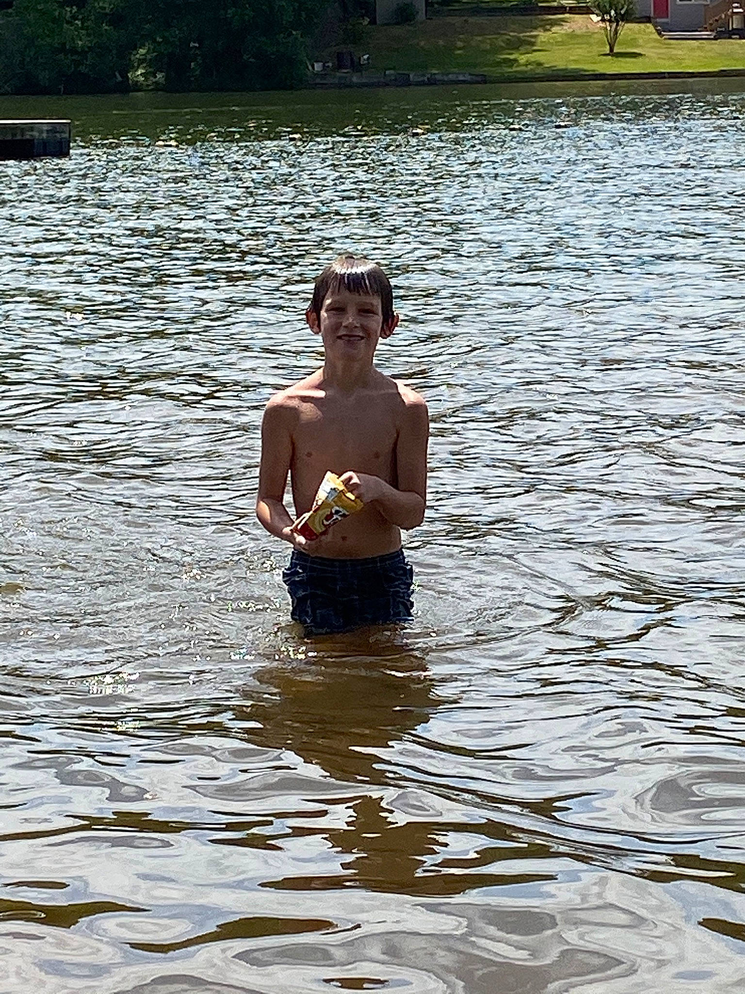 Colby is registered to the contest to win money with this photo: barechested, bathing, fun, happy, joy, lake, leisure, mammal, muscle, people_in_nature, person, personal_protective_equipment, recreation, reflection, smile, sunlight, swimwear, tree, vertebrate, water