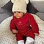 baby, beanie, bodypart, bonnet, cap, clothing, couch, cushion, face, furniture, hat, head, homedecor, hosiery, pants, person, photography, portrait, sitting, sock