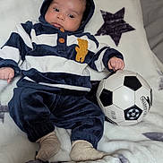 Aaron a rejoint le concours — aidez-le/la à gagner de superbes lots ! baby, blanket, brown_eyes, button, child, cozy, hoodie, indoor, infant, lying_down, plush_bedding, portrait, resting, small_hand, soccer_ball, socks, soft_texture, sports_ball, star_pattern, striped_clothing
