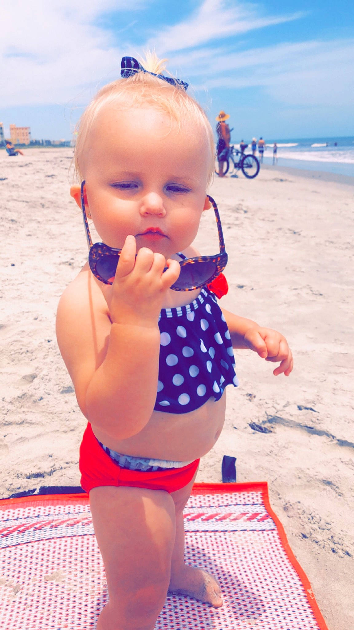 Avalynn is registered to the contest to win money with this photo: abdomen, baby, beach, child, fun, leg, leisure, pattern, person, play, polka_dot, sand, sea, summer, sun_tanning, swimwear, toddler, vacation, water