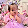toddler, child, dress, lavender, butterfly_hair_clips, flowers, pink, purple, cute, portrait, indoor, decor, baby, hand_on_face, curious_expression, soft_lighting, fairy_tale, costume, young_child, smiling