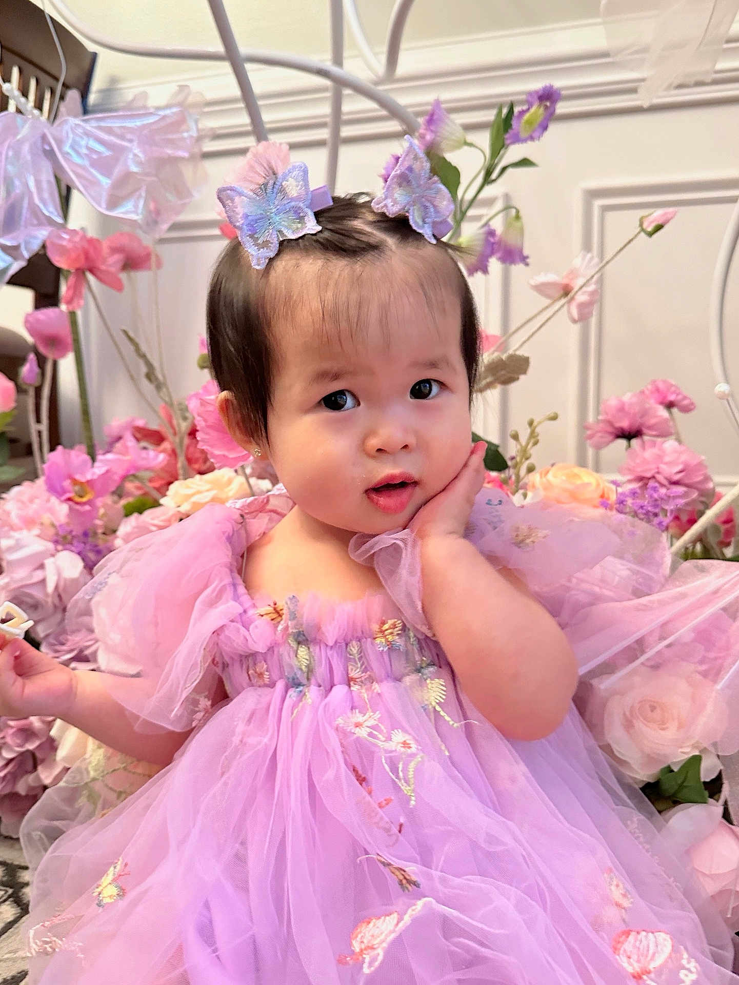 Elsie joined the competition — help win amazing prizes! toddler, child, dress, lavender, butterfly_hair_clips, flowers, pink, purple, cute, portrait, indoor, decor, baby, hand_on_face, curious_expression, soft_lighting, fairy_tale, costume, young_child, smiling