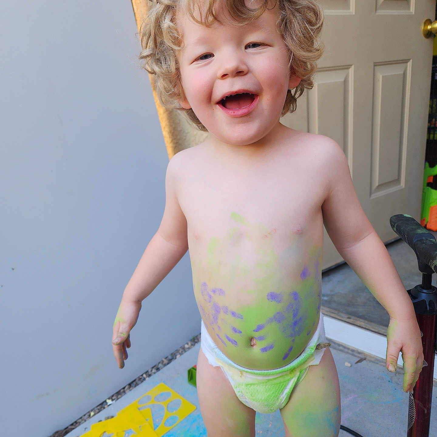 Jayden Blodgett joined the competition — help win amazing prizes! bare_chest, chalk, chalk_paint, child, colorful, concrete_floor, curly_hair, diaper, door, feet, fun, hand_painted, happy, messy, outdoor, playful, pump, smiling, stencils, toddler