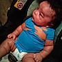 baby, infant, car_seat, blue_clothing, diaper, child, cute, chubby, sitting, indoors, person, face, curious, young, plump, seat_belt, warning_label, skin, human, portrait