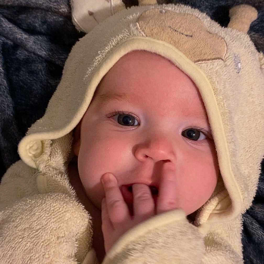 Liam joined the competition — help win amazing prizes! baby, blanket, child, cozy, cute, expression, eyes, face, fingers, giraffe, hood, indoors, infant, mouth, person, portrait, skin, sleepwear, soft, towel