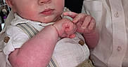 Adam is registered to the contest to win money with this photo: adult, baby, child, closeup, clothing, cute, expression, face, fingers, hand, holding, indoor, infant, pants, person, portrait, shirt, skin, suspenders, young