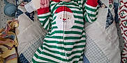 Adam is registered to the contest to win money with this photo: baby, infant, christmas_pajamas, santa_hat, blanket, quilt, stuffed_toy, pacifier, bed, face, sleepwear, holiday, cute, child, lying_down, soft_toys, cozy, expression, indoor, newborn
