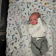 Adam joined the competition — help win amazing prizes! baby, infant, blanket, footprint_pattern, clothing, white_shirt, gray_pants, face, lying_down, crib, soft_texture, animal_print, cute, newborn, person, indoors, sleeping_area, baby_bedding, small_hands, baby_foot