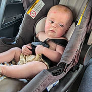 Adam is registered to the contest to win money with this photo: baby, car_interior, car_seat, casual, child, clothing, expression, face, hands, head, indoors, infant, legs, person, safety, seatbelt, sitting, skin, straps, young