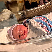 Ethan is registered to the contest to win money with this photo: newborn, baby, hospital, bassinet, blanket, hat, infant, bed, resting, wrapped, person, face, sleeping, indoor, medical, nursery, cute, peaceful, newborn_baby, portrait