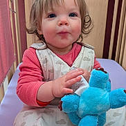 Alice a rejoint le concours — aidez-le/la à gagner de superbes lots ! baby, child, crib, plush_toy, blue_toy, sleep_sack, pink_clothing, curly_hair, indoor, wooden_crib, infant, cute, person, toddler, hand, face, expression, sitting, nursery, soft_toy