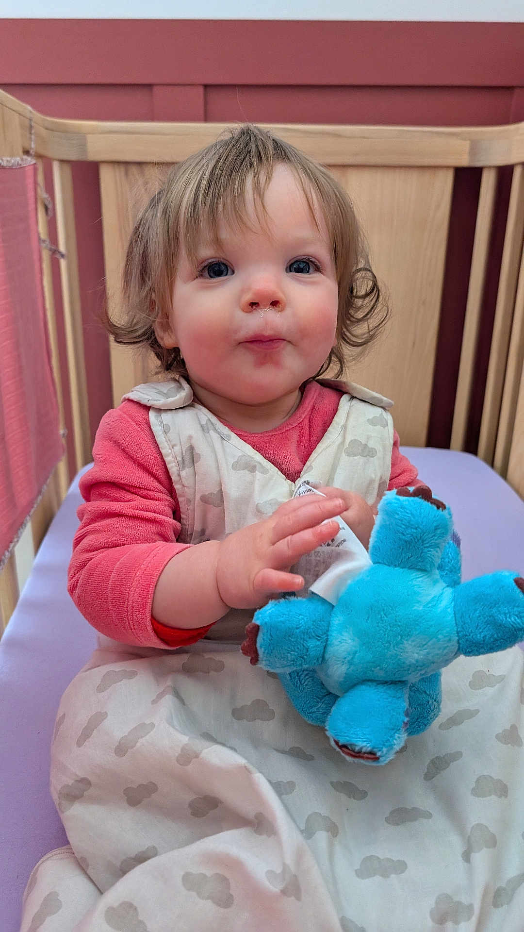 Alice a rejoint le concours — aidez-le/la à gagner de superbes lots ! baby, child, crib, plush_toy, blue_toy, sleep_sack, pink_clothing, curly_hair, indoor, wooden_crib, infant, cute, person, toddler, hand, face, expression, sitting, nursery, soft_toy