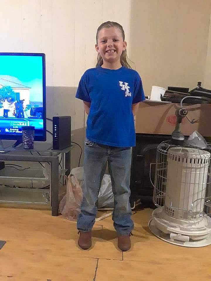 Caitlyn is registered to the contest to win money with this photo: display_device, electric_blue, entertainment_center, event, flat_panel_display, flooring, gadget, gas, hardwood, home_appliance, joy, led_backlit_lcd_display, machine, output_device, person, room, smile, standing, t_shirt, television