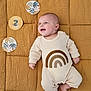 Camille participe au concours pour gagner de l'argent avec cette photo : baby, infant, smile, lying_down, blanket, quilted, yellow, cream_outfit, rainbow_design, decorative_cards, 2_months, child, cute, happy, indoors, portrait, one_person, foot, hand, head