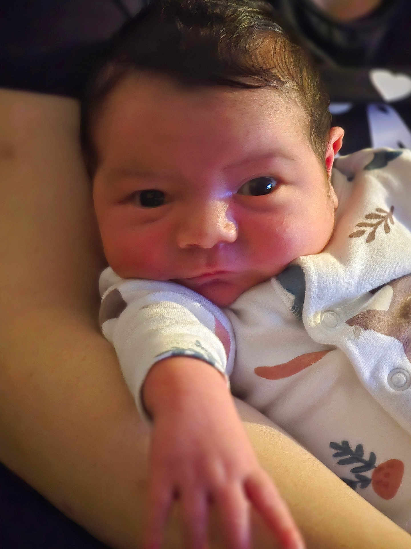 Malik participe au concours pour gagner de l'argent avec cette photo : baby, newborn, infant, face, hand, onesie, patterned_clothing, arm, skin, close_up, portrait, curious, resting, soft_lighting, person, child, cute, indoors, young, human