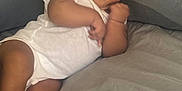 Aaliyah joined the competition — help win amazing prizes! baby, infant, onesie, bed, gray_bed, soft, curious, face, skin, fist, foot, relaxed, indoors, child, cute, lying_down, comfort, young, portrait, person