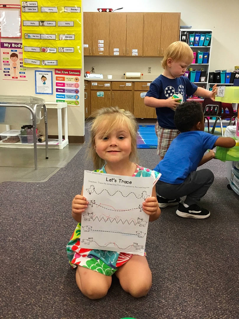 Kylinn is registered to the contest to win money with this photo: chair, child, customer, event, flooring, fun, human_leg, joy, kindergarten, leg, leisure, person, play, retail, room, service, shelf, sitting, standing, t_shirt