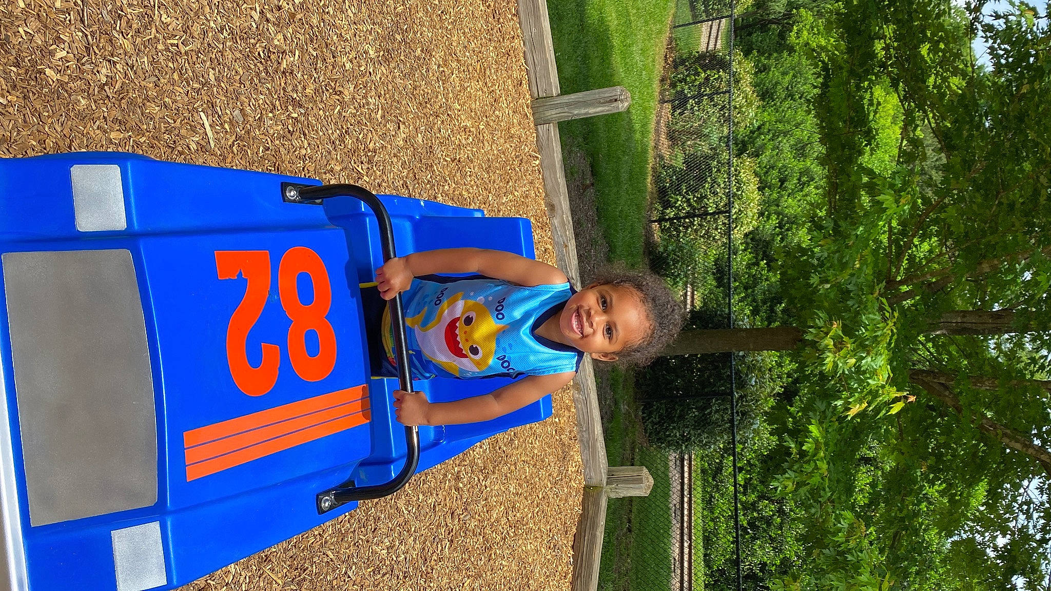 Marcus is registered to the contest to win money with this photo: asphalt, automotive_exterior, child, city, electric_blue, fun, gas, grass, joy, leisure, machine, motor_vehicle, outdoor_play_equipment, person, plant, play, public_utility, recreation, smile, t_shirt