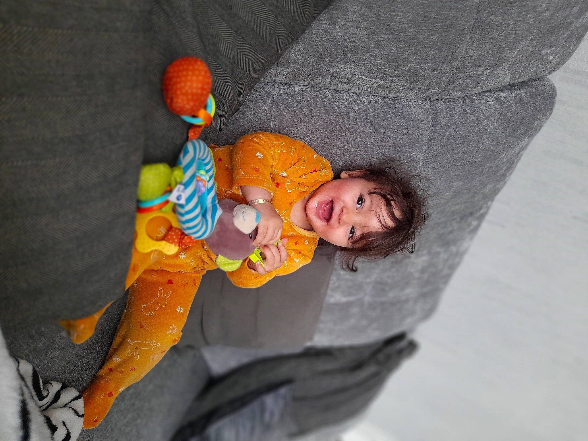 Nour participe au concours pour gagner de l'argent avec cette photo : baby_products, baby_toddler_clothing, child, comfort, doll, eye, fun, head, orange, outerwear, person, recreation, room, sleeve, smile, stuffed_toy, textile, toddler, toy, tree