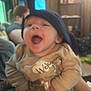 Arizona joined the competition — help win amazing prizes! baby, child, infant, laughing, hat, clothing, indoor, person, smile, cozy, blurred_background, furniture, sleeves, warm_lighting, hand, face, expression, happy, young_child, people