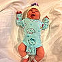 Arizona is registered to the contest to win money with this photo: baby, newborn, infant, smiling, onesie, hat, blanket, lying_down, cute, happy, child, footbands, indoor, soft, pink_cheeks, clothing, face, person, warm, cozy