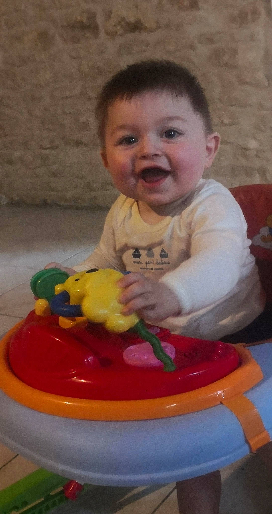 Timoté participe au concours pour gagner de l'argent avec cette photo : arm, baby, baby_playing_with_toys, baby_toddler_clothing, cheek, child, facial_expression, finger, fun, happy, head, person, plastic, play, recreation, sitting, skin, smile, standing, toddler