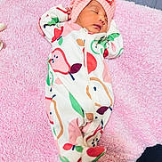 Iravya is registered to the contest to win money with this photo: baby, newborn, sleeping, pink_blanket, onesie, headwrap, bow, fruit_pattern, infant, child, soft_texture, cozy, cute, peaceful, indoor, portrait, person, sleep, rest, toddler